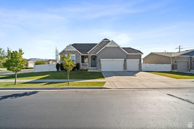 665 S 1400 W, Syracuse, UT 84075 - view of front of property featuring a front yard, an attached garage, stone siding, fence, and concrete driveway