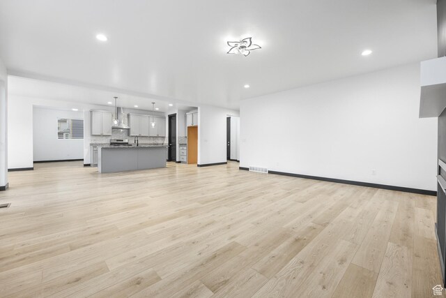 2867 S Greenhead Dr, Saratoga Springs, UT 84045 - unfurnished living room featuring recessed lighting, light wood-style flooring, baseboards, and visible vents