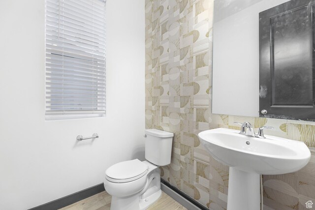 2867 S Greenhead Dr, Saratoga Springs, UT 84045 - half bathroom with a sink, toilet, wood finished floors, and baseboards