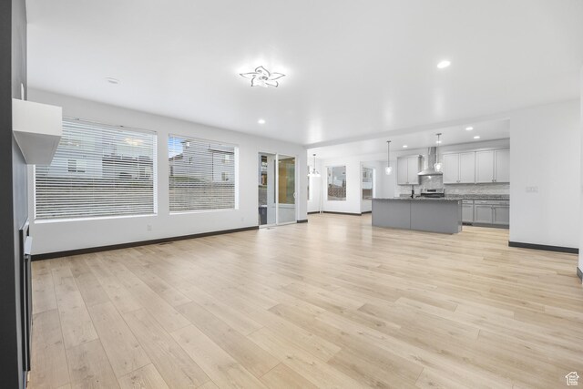2867 S Greenhead Dr, Saratoga Springs, UT 84045 - unfurnished living room with light wood finished floors, baseboards, and recessed lighting