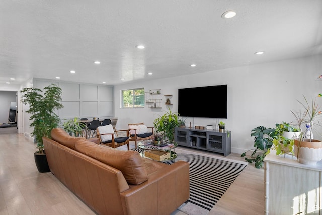 living area featuring baseboards, wood finished floors, and recessed lighting