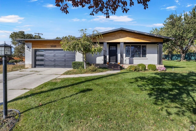 view of front of home with brick siding, an attached garage, a front lawn, and driveway