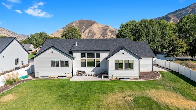 rear view of property with a fenced backyard, a yard, a patio, entry steps, and a mountain view