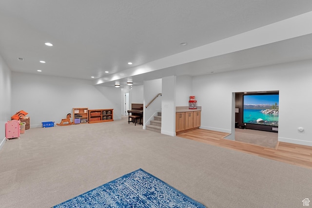 recreation room with light colored carpet, recessed lighting, and baseboards