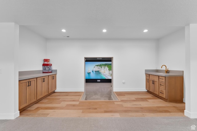 bar featuring recessed lighting, light wood-style flooring, a sink, baseboards, and visible vents