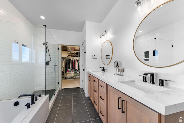 full bath with double vanity, tile patterned flooring, a stall shower, and a sink