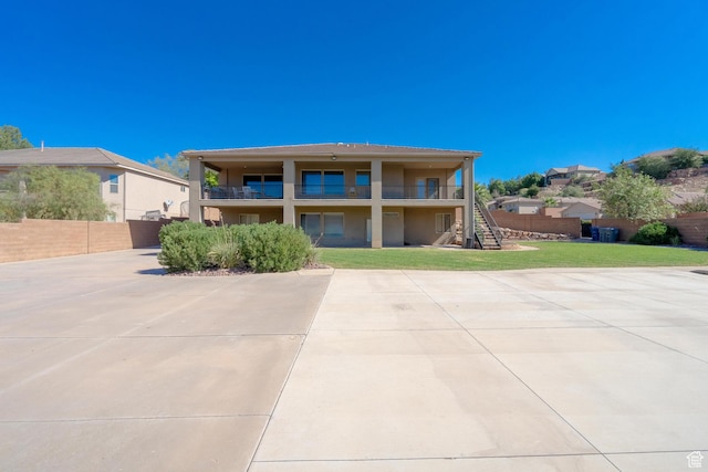 2042 Westcliff Dr, St George, UT 84790 - rear view of property with fence, a lawn, stairs, a balcony, and stucco siding