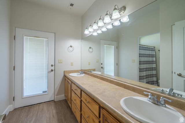 2042 Westcliff Dr, St George, UT 84790 - full bathroom with double vanity, wood finished floors, visible vents, and a sink