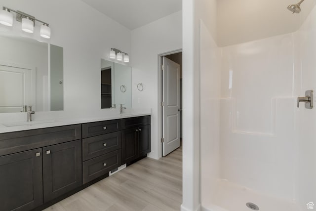bathroom featuring vanity, hardwood / wood-style flooring, and a shower