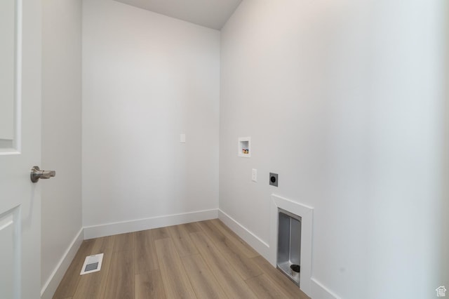 clothes washing area featuring electric dryer hookup, washer hookup, and light hardwood / wood-style flooring