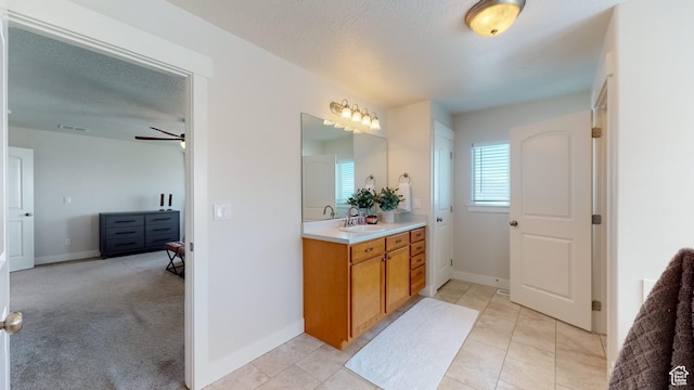 bathroom with ceiling fan, vanity, and baseboards