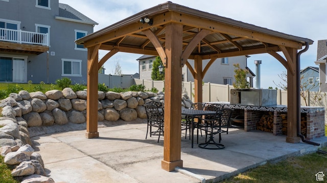 view of patio / terrace with fence, a gazebo, and outdoor dining space