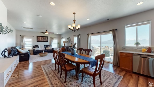 dining space featuring recessed lighting, light wood-style flooring, and ceiling fan with notable chandelier