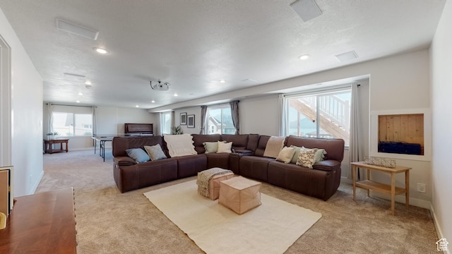 living room featuring recessed lighting, light colored carpet, and plenty of natural light