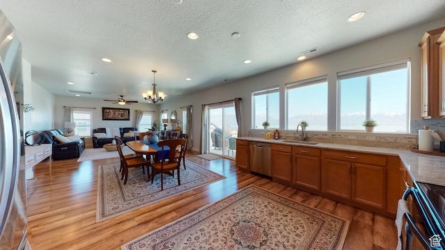 kitchen featuring a sink, appliances with stainless steel finishes, visible vents, an inviting chandelier, and light wood-type flooring