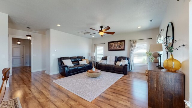 living area with light wood-type flooring, a ceiling fan, recessed lighting, and baseboards