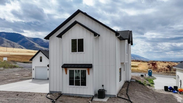 1153 E 160 N, Hyde Park, UT 84318 - back of house with board and batten siding, concrete driveway, a mountain view, and a garage