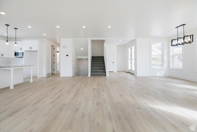 1153 E 160 N, Hyde Park, UT 84318 - unfurnished living room with recessed lighting, stairway, baseboards, and light wood-style flooring
