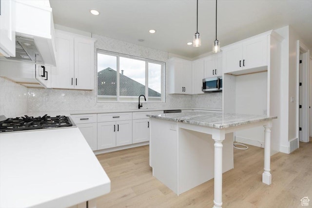 1153 E 160 N, Hyde Park, UT 84318 - kitchen featuring a sink, gas cooktop, light wood-type flooring, stainless steel microwave, and backsplash