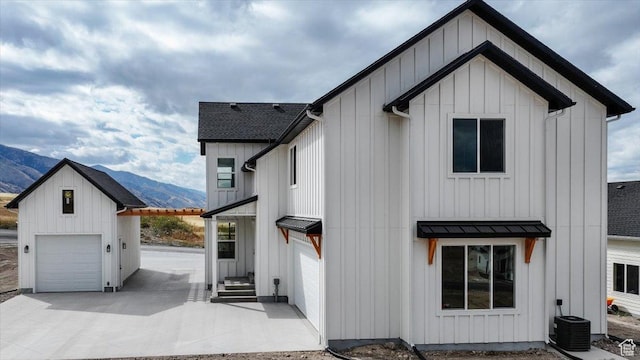 1153 E 160 N, Hyde Park, UT 84318 - view of front of property with board and batten siding, a standing seam roof, a mountain view, and a garage