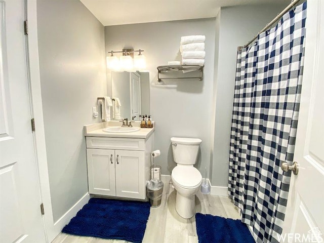 942 N Newberg Dr Unit 2, Garden City, UT 84028 - bathroom with baseboards, toilet, vanity, and wood finished floors