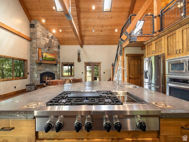 2050 W 2130 N, Helper, UT 84526 - kitchen featuring a stone fireplace, appliances with stainless steel finishes, wooden ceiling, a sink, and open floor plan
