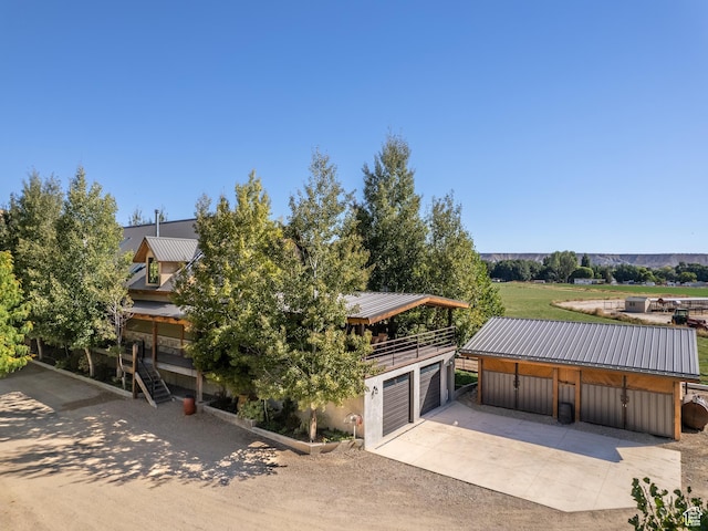 2050 W 2130 N, Helper, UT 84526 - view of front of house with concrete driveway, an outdoor structure, stairway, a garage, and metal roof