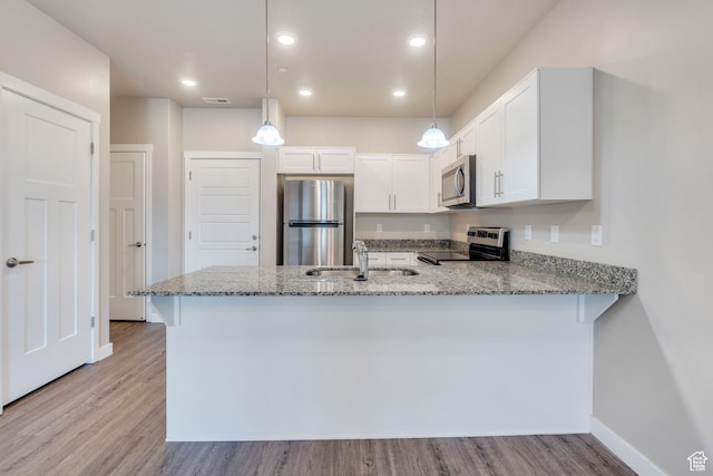548 E 300 N, Vineyard, UT 84059 - kitchen featuring light stone countertops, a peninsula, appliances with stainless steel finishes, and a sink