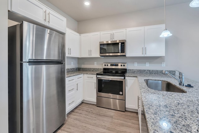 548 E 300 N, Vineyard, UT 84059 - kitchen with light stone counters, stainless steel appliances, light wood finished floors, a sink, and white cabinetry