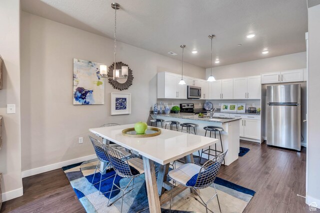 265 N 670 E, Vineyard, UT 84059 - kitchen featuring white cabinetry, stainless steel appliances, baseboards, dark wood-type flooring, and a peninsula