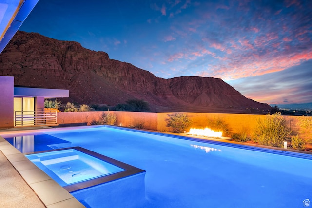 973 W Sipala Trl, Ivins, UT 84738 - pool at dusk featuring an in ground hot tub and a mountain view