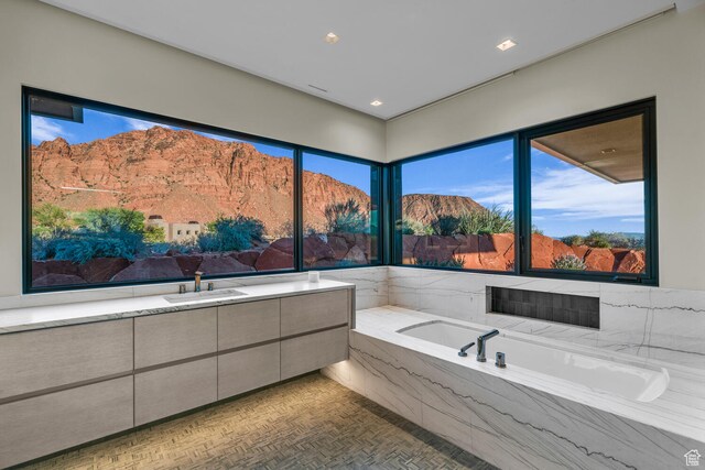 973 W Sipala Trl, Ivins, UT 84738 - bathroom with a mountain view, a relaxing tiled tub, sink, and parquet floors
