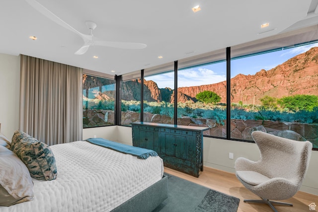 973 W Sipala Trl, Ivins, UT 84738 - bedroom featuring ceiling fan, a mountain view, light hardwood / wood-style flooring, and floor to ceiling windows