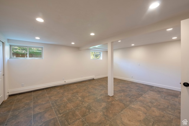 basement featuring a wealth of natural light and a baseboard radiator