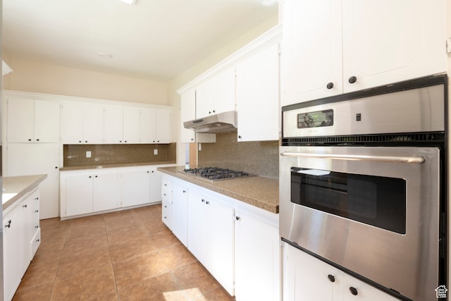 kitchen featuring decorative backsplash, appliances with stainless steel finishes, light tile patterned floors, and white cabinetry