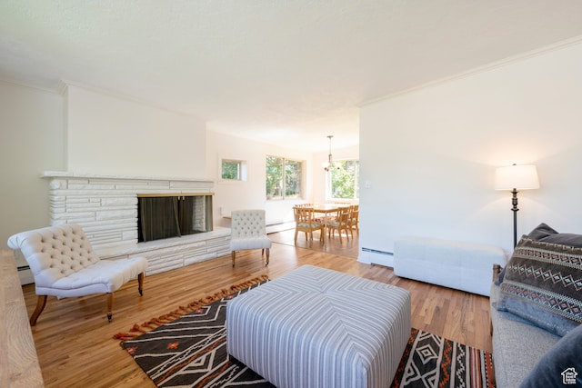 living room featuring a stone fireplace, a baseboard radiator, and hardwood / wood-style floors