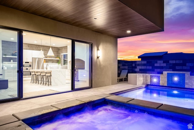 3617 S Cypress Point Rd, Hurricane, UT 84737 - pool at dusk with an in ground hot tub and an outdoor wet bar