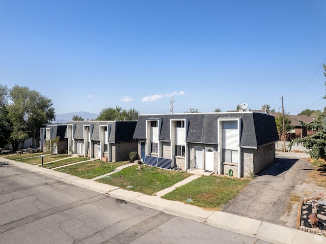 435 E 790 S Unit 8, Pleasant Grove, UT 84062 - view of front of property featuring a shingled roof, a front lawn, brick siding, and mansard roof