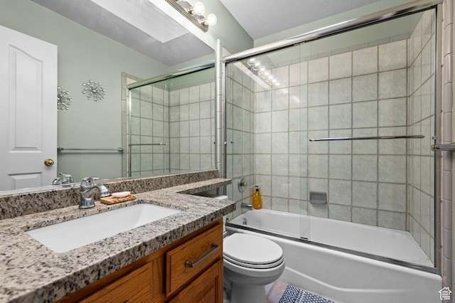 bathroom with vanity, combined bath / shower with glass door, and toilet