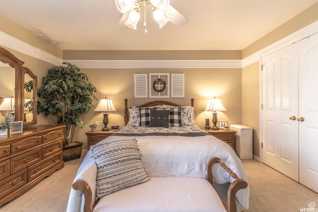 bedroom with ceiling fan, a closet, and light colored carpet