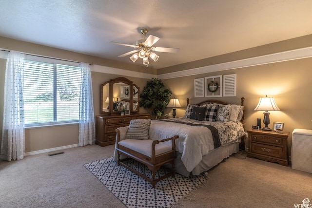 bedroom with a ceiling fan, baseboards, light colored carpet, and visible vents