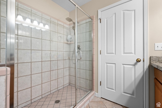 bathroom featuring tile patterned flooring, a stall shower, and vanity
