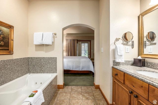 bathroom with a jetted tub, vanity, baseboards, tile patterned floors, and connected bathroom