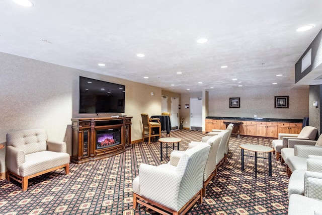 carpeted living area with recessed lighting and a glass covered fireplace
