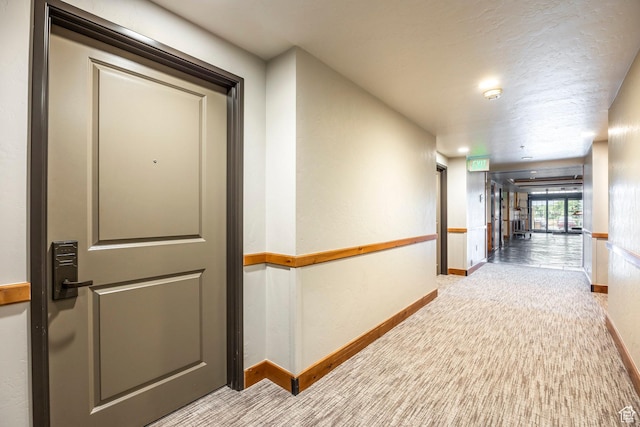 corridor with baseboards and carpet floors