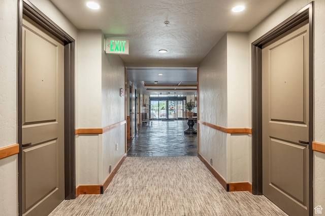 hallway featuring carpet floors, baseboards, recessed lighting, and a textured ceiling
