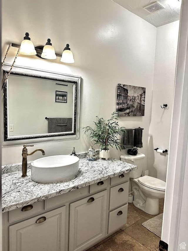 1350 E 600 S, Richfield, UT 84701 - bathroom featuring stone finish flooring, vanity, visible vents, and toilet