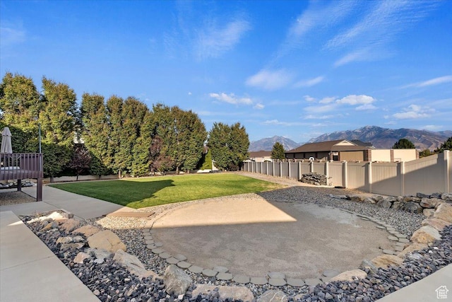 view of yard featuring fence, a patio, and a mountain view