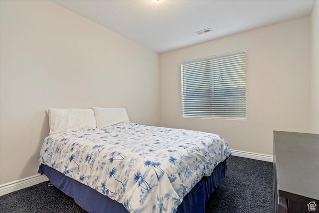 bedroom with visible vents, dark carpet, and baseboards