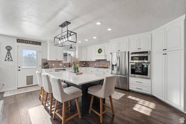 dining area with dark wood-style floors, recessed lighting, a textured ceiling, and baseboards